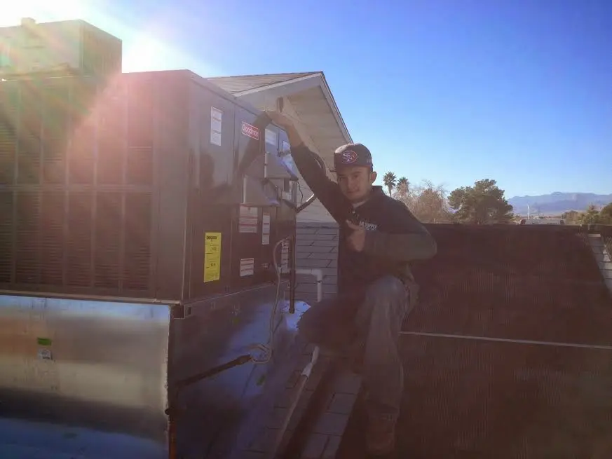 HVAC technician performing Boiler Repair on a rooftop unit in Linton